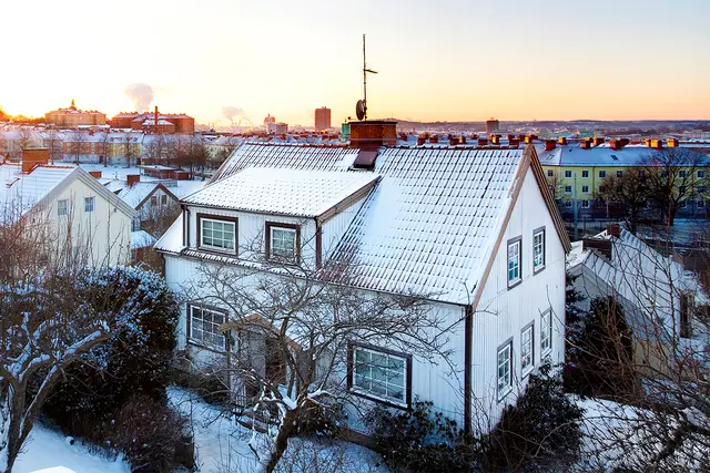 Hus med snö och frost på taket